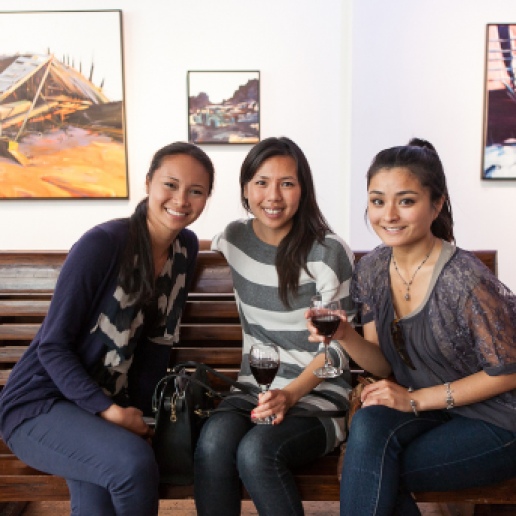 Visitors enjoy a glass of wine at a local gallery